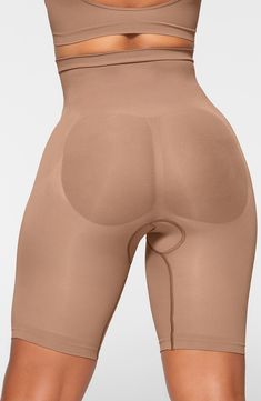 Sculpt your body's natural shape with high-waist shorts that hit just above the knee with a whisper-soft and seamless design from Kim Kardashian's SKIMS. Reflecting the brand's passion for highly technical shapewear solutions for every body, this staple piece smoothes your upper legs while lifting your butt and comes in different shades to complement your skin tone. 82% nylon, 18% elastane Machine wash, tumble dry Imported High Waist Shapewear Shorts With Built-in Bra, Sculpting Seamless Mid-thigh Bottoms, Sculpting Seamless Mid-thigh Length Bottoms, Beige Shapewear With Built-in Bra, Short Length, Compressive Bottoms With Built-in Bra Mid-thigh Length, Solid Sculpting Shapewear Mid-thigh Length, Sculpting Solid Color Shapewear Mid-thigh Length, Sculpting Shapewear Shorts, Solid Sculpting Shapewear In Short Length