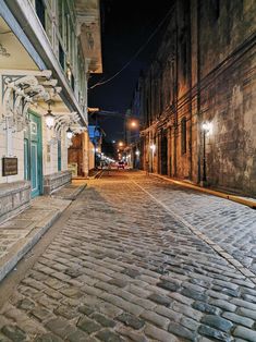 an empty cobblestone street at night