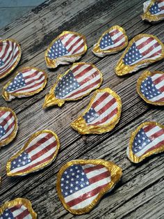 american flag shaped cookies on wooden table with gold foil decorations and one cookie in the shape of an american flag