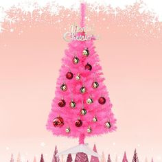 a pink christmas tree with ornaments on it in the middle of a snow covered field