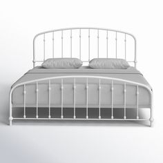 a white metal bed frame with two pillows