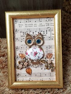 an owl is sitting on top of sheet music and surrounded by other musical notes in a gold frame