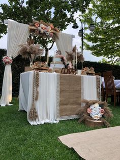 an outdoor table set up for a wedding reception with flowers and feathers on the table