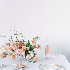 the table is set with flowers and silverware