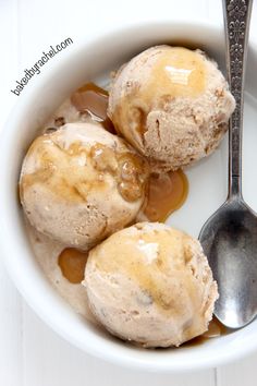 three scoops of ice cream in a bowl with caramel sauce