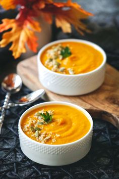 two white bowls filled with soup on top of a table