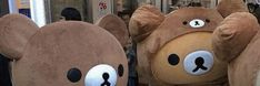 two large teddy bears are standing in front of each other with faces on their backs