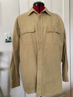 "Here is an L.L. Bean chamois shirt is khaki/ tan. It is made of cotton and is marked a size large. It measures approximately 48\" at the chest, 19\" across the shoulders, 23\" arm length, 7.5\" shoulder seam and 31\" center back length. It has some spots of discoloration on the right and left cuff and a small smudge on the left side about 5\" down from the pocket. Please see pictures." Chamois Shirt, Tan Shirt, Vintage Ll Bean, L L Bean, Flannel Shirt, Plaid Shirt, Ups, Float, Wool Blend