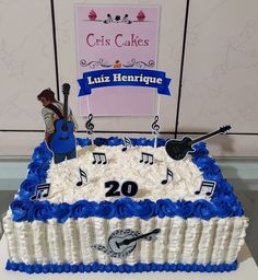 a sheet cake decorated with musical instruments and music notes is displayed in front of a sign that reads luiz hertique 20