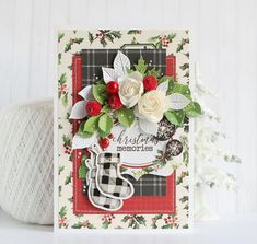 a christmas card with holly and white flowers