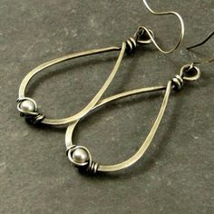 Eco friendly sterling silver (16G) has been hand formed and hammered into teardrops. An organic spiral has been wire wrapped around a 4mm cream Swarovski pearl. The teardrops have been oxidized and lightly brushed with steel wool and then polished for a soft patina. Ear wires are hand formed from sterling silver. Earrings measure 2.75 inches from top of ear wire to bottom of teardrop. All silver used has come from a recycled source. All pieces come in a craft box wrapped in a ribbon that is tied Everyday Handmade Teardrop Pearl Earrings, Classic Metal Teardrop Earrings As Gift, Classic Metal Teardrop Earrings For Gift, Classic Handmade Teardrop Hoop Earrings, Classic Metal Teardrop Pierced Earrings, Silver Teardrop Pearl Earrings For Everyday, Teardrop Metal Pearl Earrings, Teardrop Pearl Earrings With Metal Ear Wire, Handmade Teardrop Metal Pearl Earrings