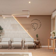 an empty waiting room with white chairs and a plant in front of the wall that says chambrele park