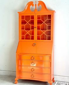 an orange china cabinet sitting on top of a white floor