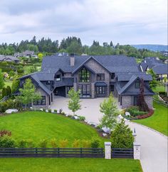 an aerial view of a large house with lots of grass and trees in the background