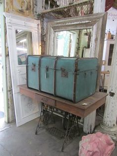 two suitcases sitting on top of a wooden table in front of a large mirror