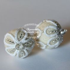 two white brooches are sitting on a table