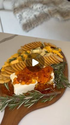 a cheese platter with crackers, olives and other toppings on it