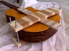 a guitar sitting on top of a wooden stand