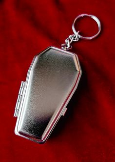 a silver pocket watch sitting on top of a red cloth