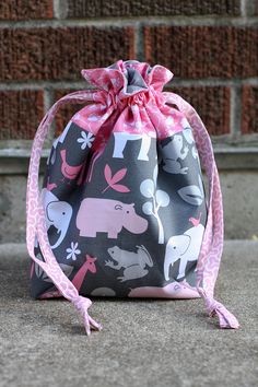 a drawsack bag sitting on the ground in front of a brick wall with an elephant print