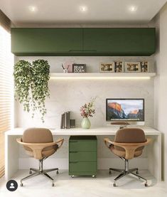 two office chairs sitting in front of a desk with a computer monitor on top of it