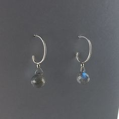 "These simple small sterling silver hoop earrings can go with any outfit. The faceted round Labradorite drops shimmer and reveals soft blue, gold, and green hues in the light. Each labradorite is about 8mm and the earrings drop length is about 1/2\" inch. An elegant design that makes the perfect gift for yourself or a loved one." Minimalist Sterling Silver Gemstone Huggie Earrings, Sterling Silver Gemstone Huggie Earrings For Everyday Wear, Dainty Faceted Everyday Earrings, Everyday Sterling Silver Gemstone Huggie Earrings, Handmade Minimalist Labradorite Earrings, Dainty Faceted Sterling Silver Earrings, Adjustable Round Labradorite Earrings, Minimalist Faceted Everyday Earrings, Minimalist Everyday Faceted Earrings