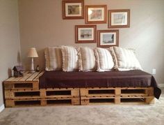 a bed made out of wooden pallets with pillows on top