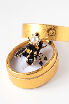 "Bay the unique bumble bee brooch as good gift idea. This bug brooch has size - 1.4*1.4 inches (3,5*3,5cm) with legs and wings It is an embroidered brooch. For production of this Insect jewelry used chenille, Czech crystal beads, pearls and a decorative element in the form of a crown made of a non-tarnishing alloy are used. This small Queen bee brooch is a symbol of good luck and prosperity. It will become a beautiful amulet or totem animal that brings happiness and wealth to its owner. Bee pin Bee Crown, Bug Brooch, Totem Animal, Spider Jewelry, Black Bee, I Love Bees, Embroidered Brooch, Bee Pin, Bee Brooch