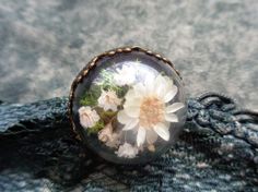 a glass ball with flowers in it sitting on top of a cloth covered tablecloth