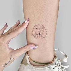 a woman's foot with a small dog tattoo on the left side of her leg