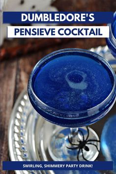 two blue drinks sitting on top of a silver tray with text overlay that reads dumbledore's expensive cocktail