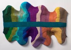 a piece of art made out of yarn that is multicolored and has stripes on it