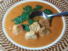 a white bowl filled with soup and croutons