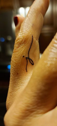 a person's hand with a small tattoo on it