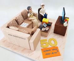 a cake that is shaped to look like a couch with a man and woman sitting on it