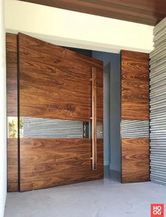 an open wooden door with metal slats on the outside and wood panels on the inside