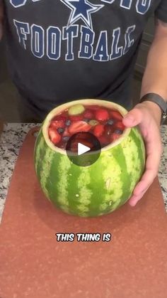 a person is holding a watermelon bowl filled with fruit and has the words, this thing is