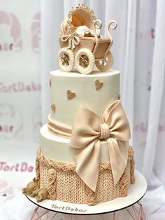 a three tiered cake with a baby carriage on top