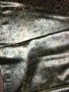 the fabric is shiny and has gold designs on it