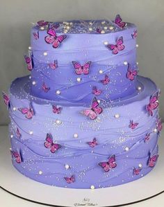 a three layer purple cake with pink butterflies on it