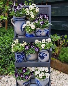 three tiered planter filled with potted flowers