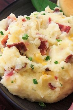 a close up of a plate of mashed potatoes with bacon and cheese on it