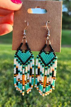 Beaded heart earrings with fringe - These are handmade by me with stainless steel earring hooks - This pair features a turquoise, orange, black, and white color palette - native made The earrings measure approximately 2 1/2 inches from top of earring not including the hook to the longest point of fringe. Please keep in mind that due to the handmade nature of these earrings, no two will be perfectly identical! This design is lovingly named The Emelie in honor of my first pair I ever made as a gif Turquoise Heart Beads Dangle Earrings, Turquoise Dangle Earrings With Heart Beads, Turquoise Fringe Earrings As Gift, Mmiw Earrings, Beaded Heart Earrings, Beaded Ideas, Seed Bead Jewelry Patterns, Beaded Charms, Stitch Earrings