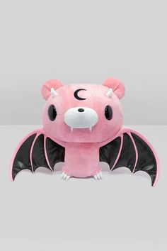 a pink bat stuffed animal sitting on top of a table