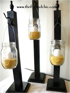 three mason jars filled with liquid sitting on top of a black stand next to each other