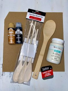 wooden spoons, paint and other items are laid out on top of a cardboard box