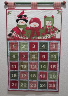 a calendar hanging on the wall with two snowmen and one is wearing a santa hat