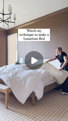 a woman standing on top of a bed in a bedroom