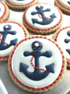 decorated cookies with blue and white icing are arranged on a baking sheet in the shape of an anchor