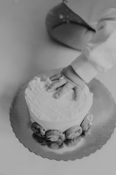 a person is decorating a cake with white frosting